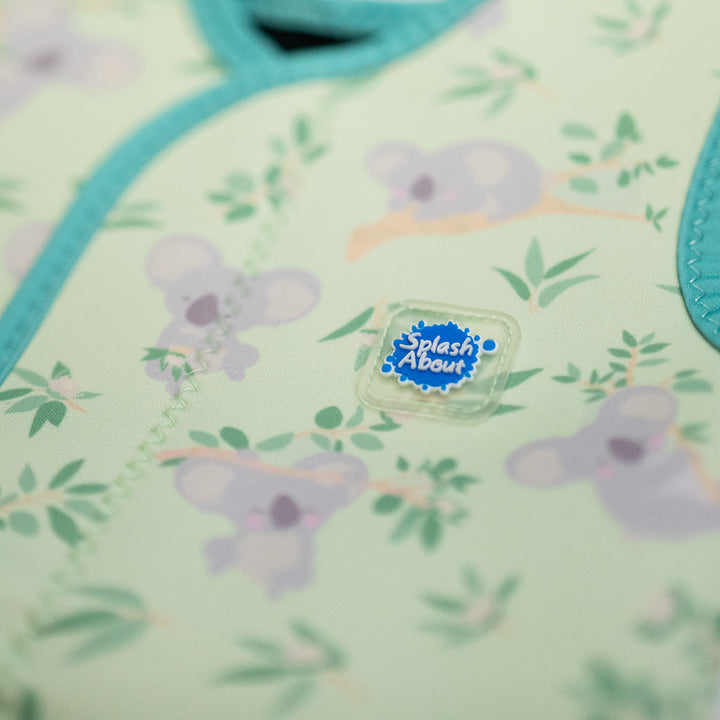 Close up of neoprene baby wrap wetsuit in light green and koalas themed print.