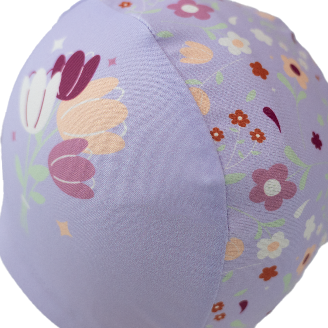 Baby swim hat in lilac featuring floral themed print.