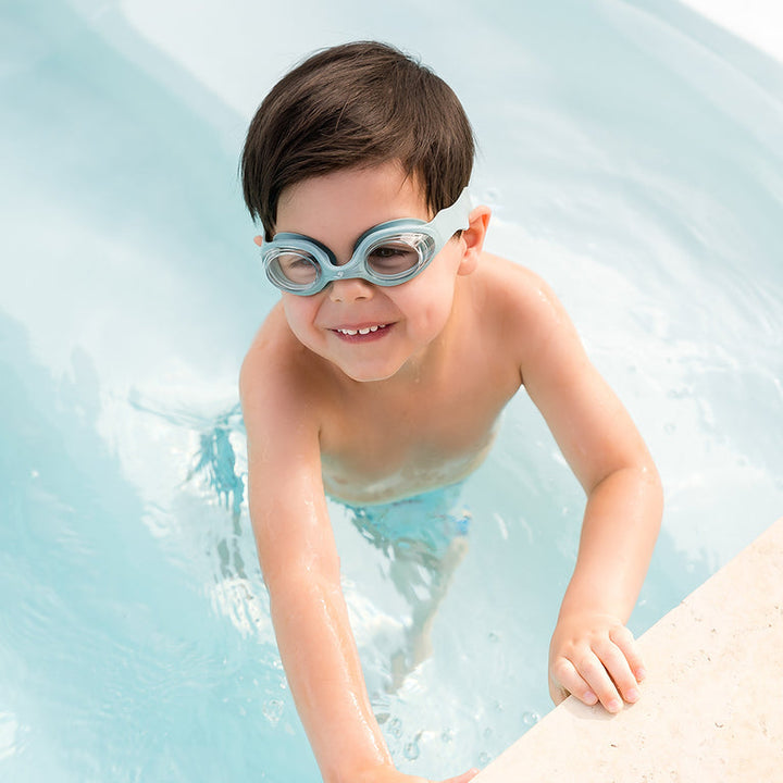 Little one wearing green goggles in the pool