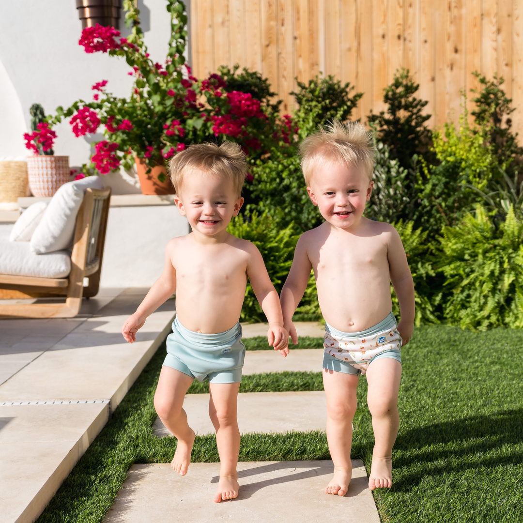 Children wearing reusable swim diaper in pistachio. Front