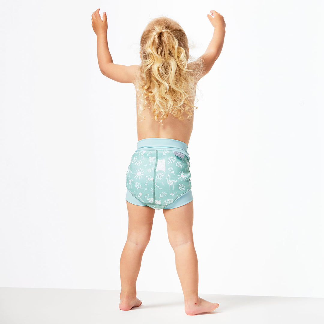 Little one wearing Happy Nappy in greenish blue, featuring animals themed print in white. Back.