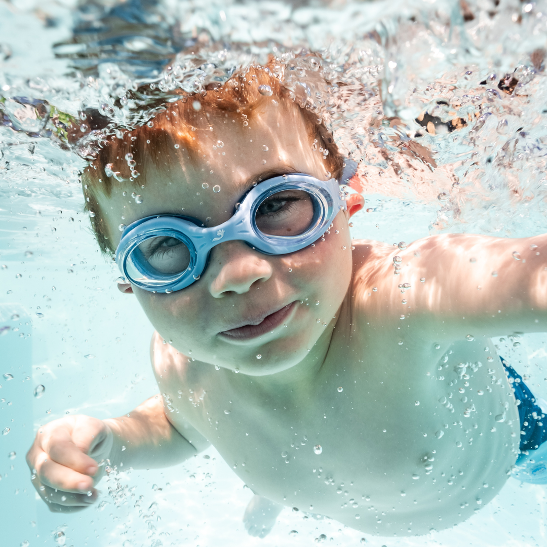 Little one wearing blue goggles underwater