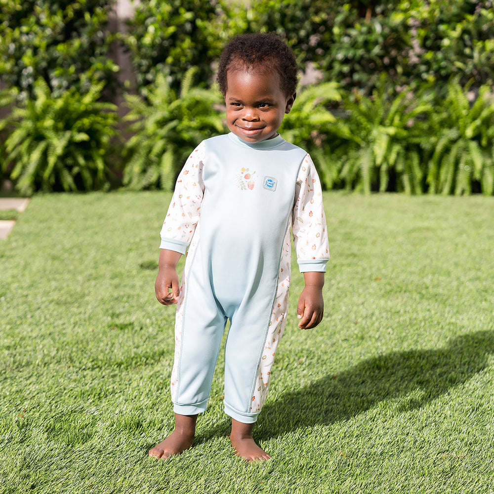 Child wearing acorns themed baby wetsuit in white and light blue.